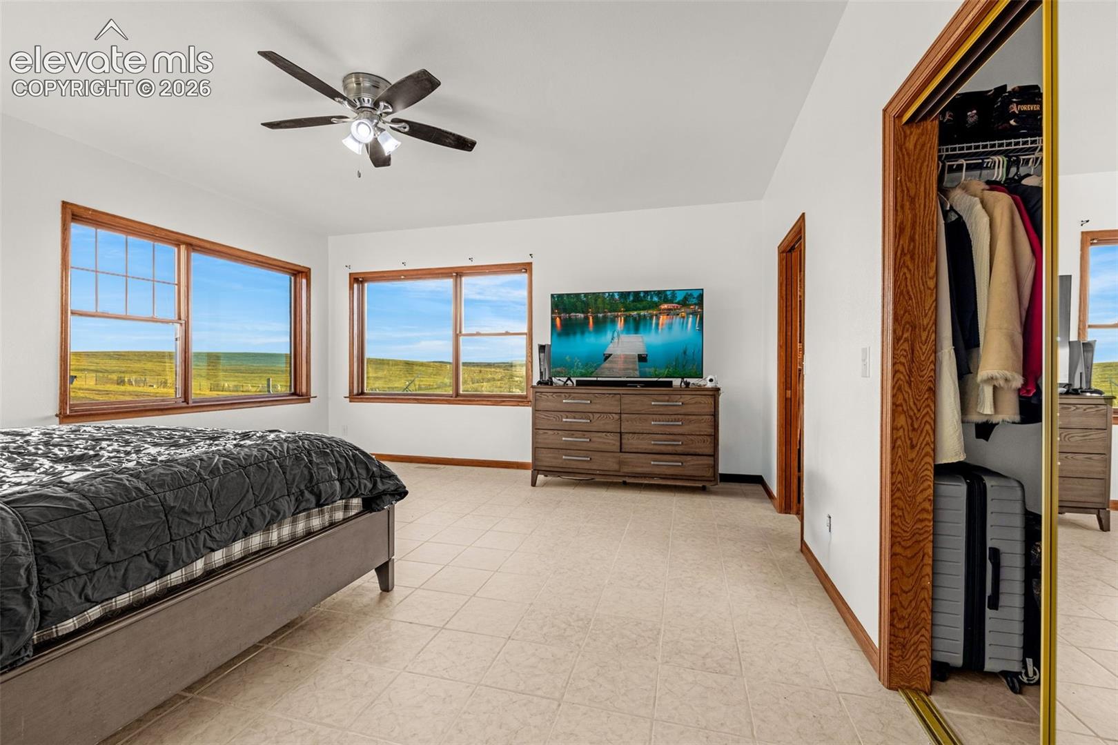 White wall finishes, tile flooring, and wood-trim windows