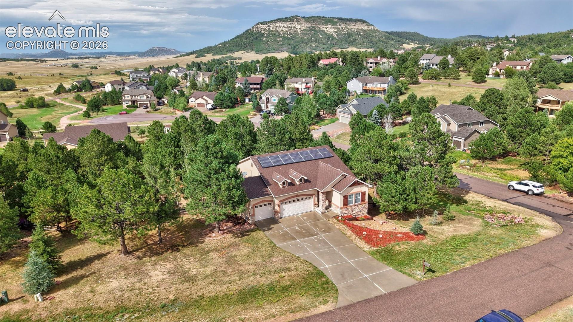 Ranch-style exterior with a shingle roof and solar panels