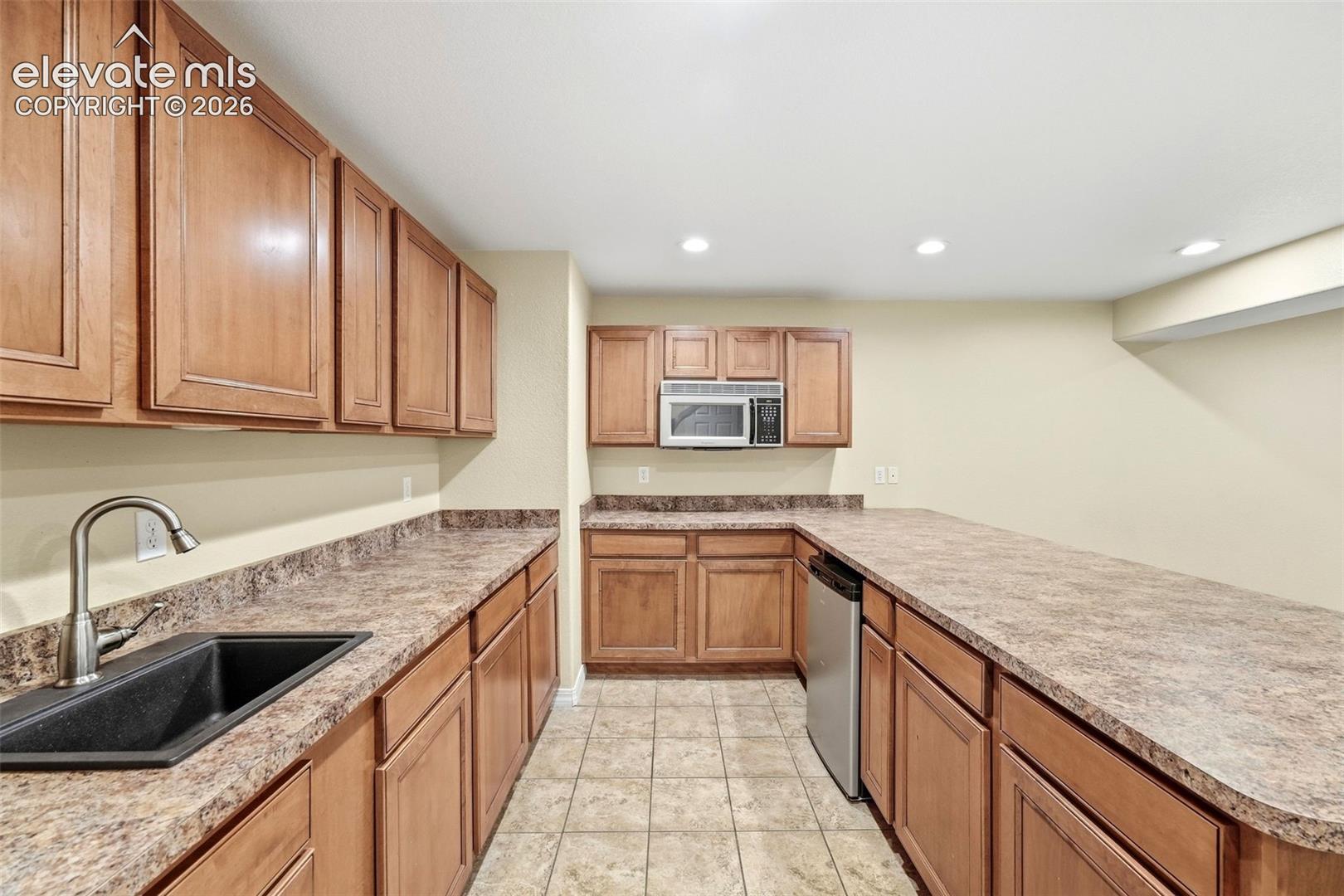 Kitchenette Features Sink and Stainless Steel Microwave/Dishwasher