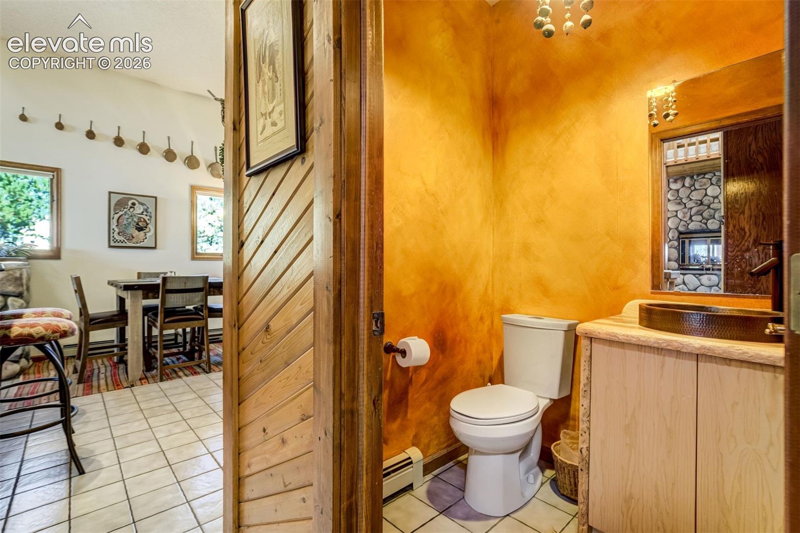 Custom vanity and hammered copper sink in the 1/2 bath off kitchen and close to entrance 