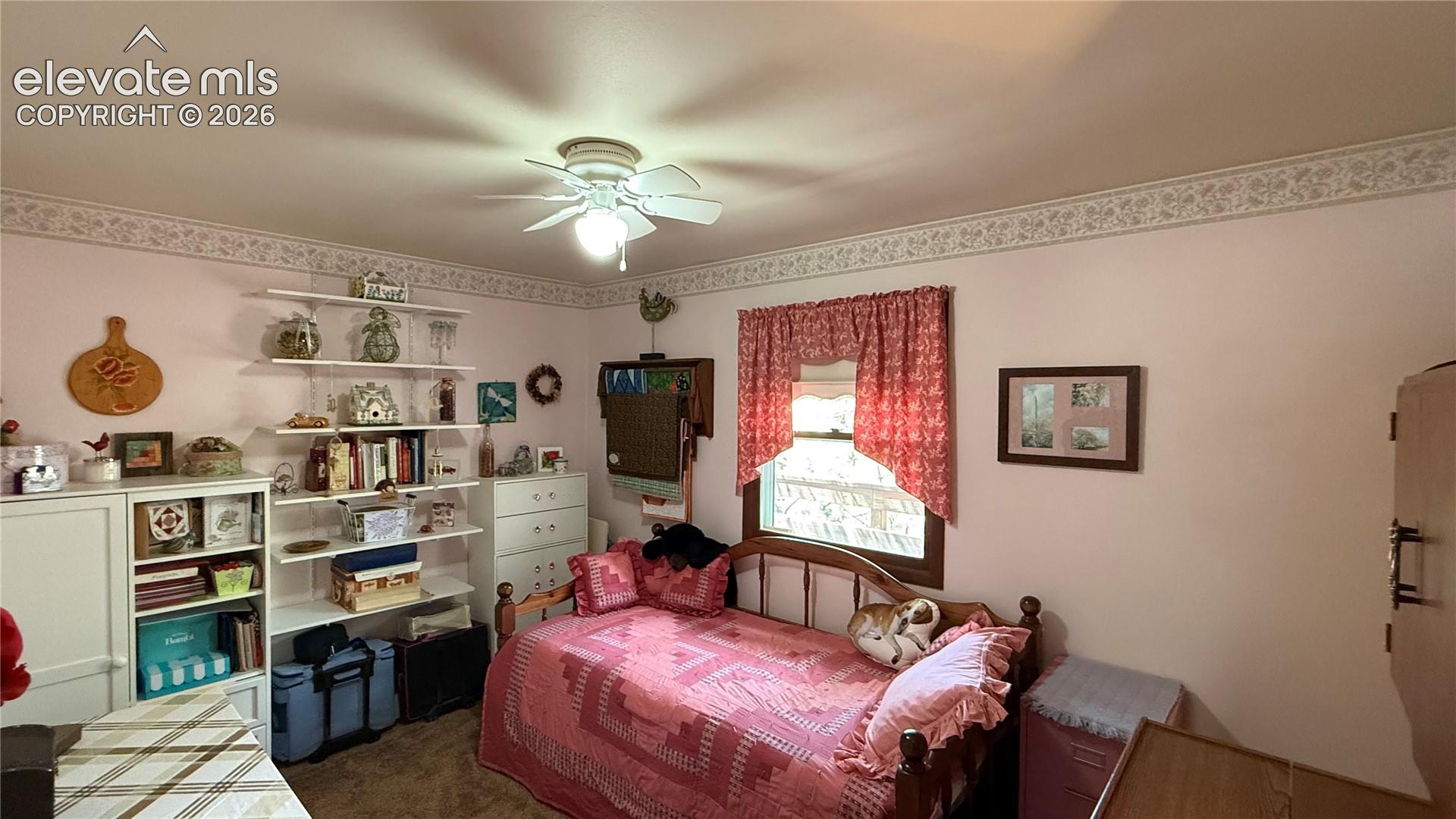 Room featuring light pink walls and a decorative wallpaper border