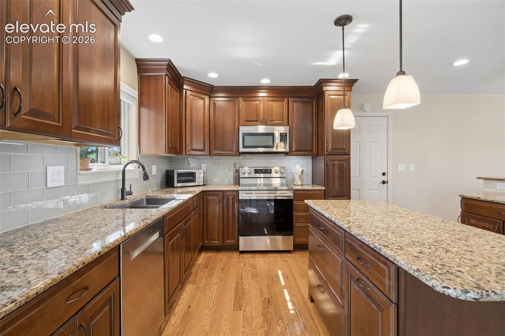 Updated kitchen featuring granite countertops and glass subway tile backsplash