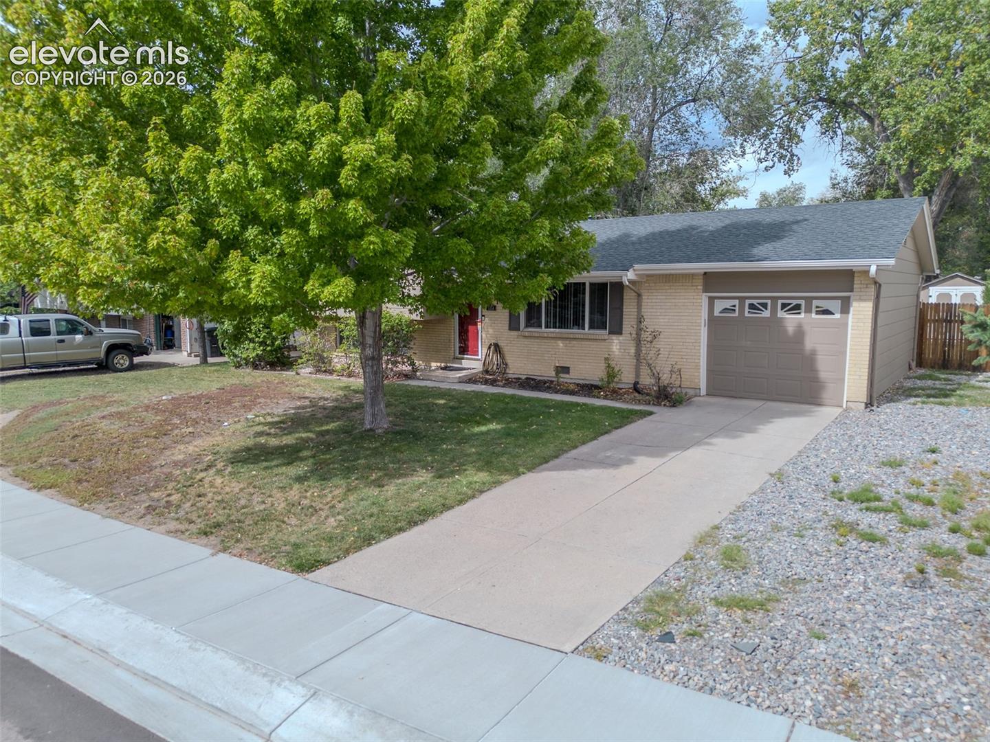 Attached single-car garage featuring a tan overhead door