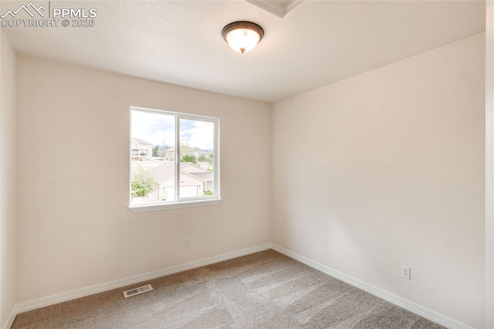 First upstairs bedroom with white walls and a closet with sliding doors