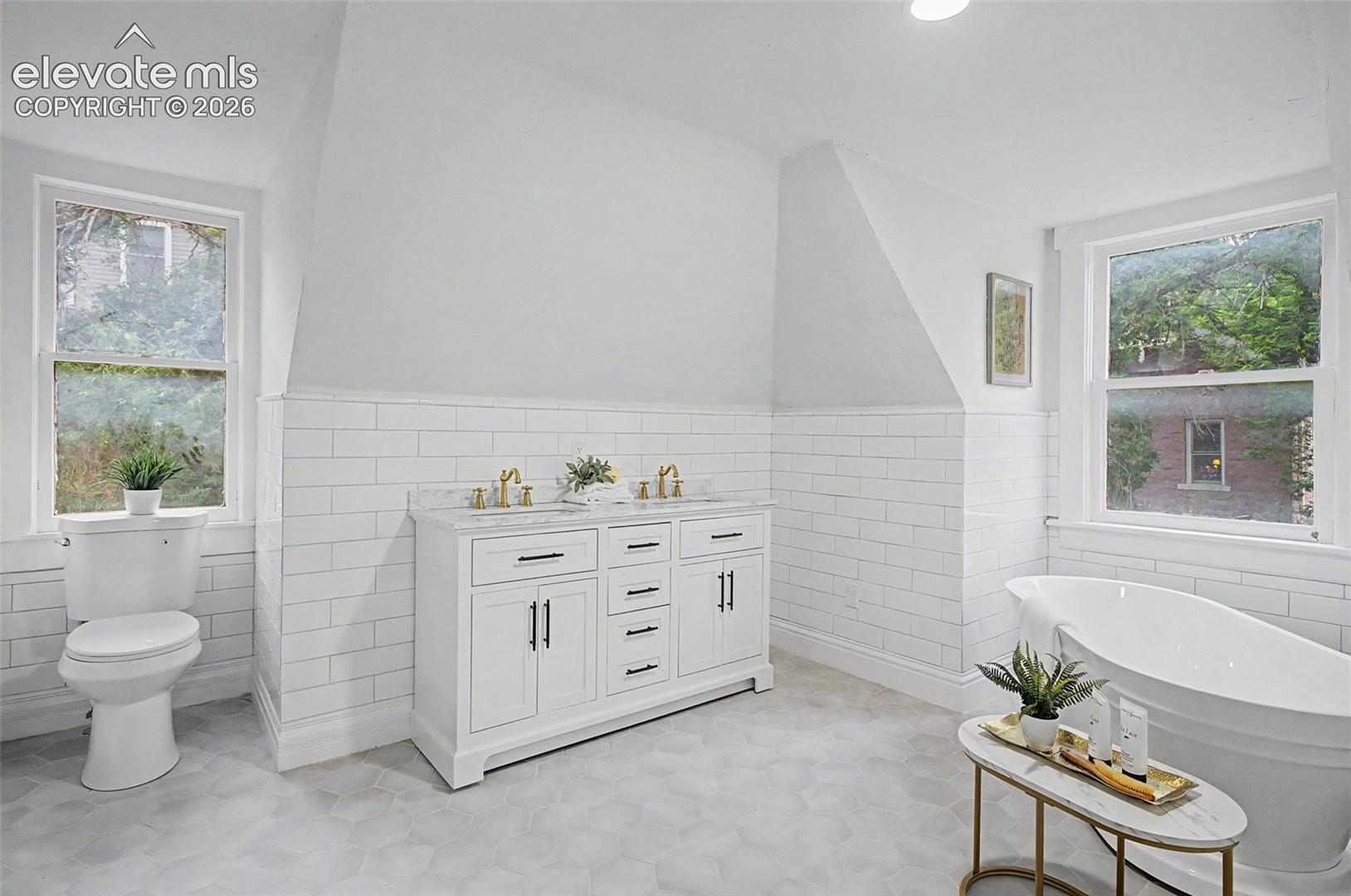 Dual vanity featuring a white cabinet with dark hardware and a light-toned countertop
