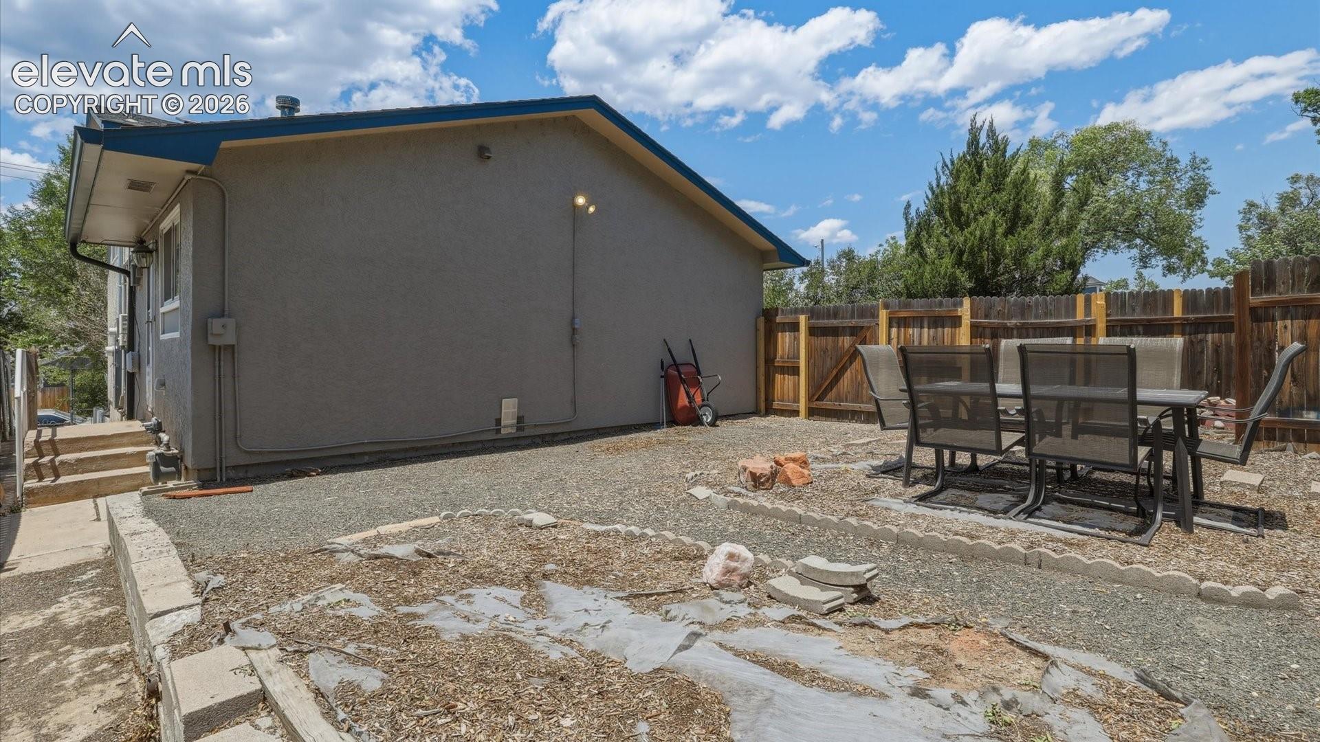 The fenced backyard offers plenty of space to relax, garden, or entertain. 