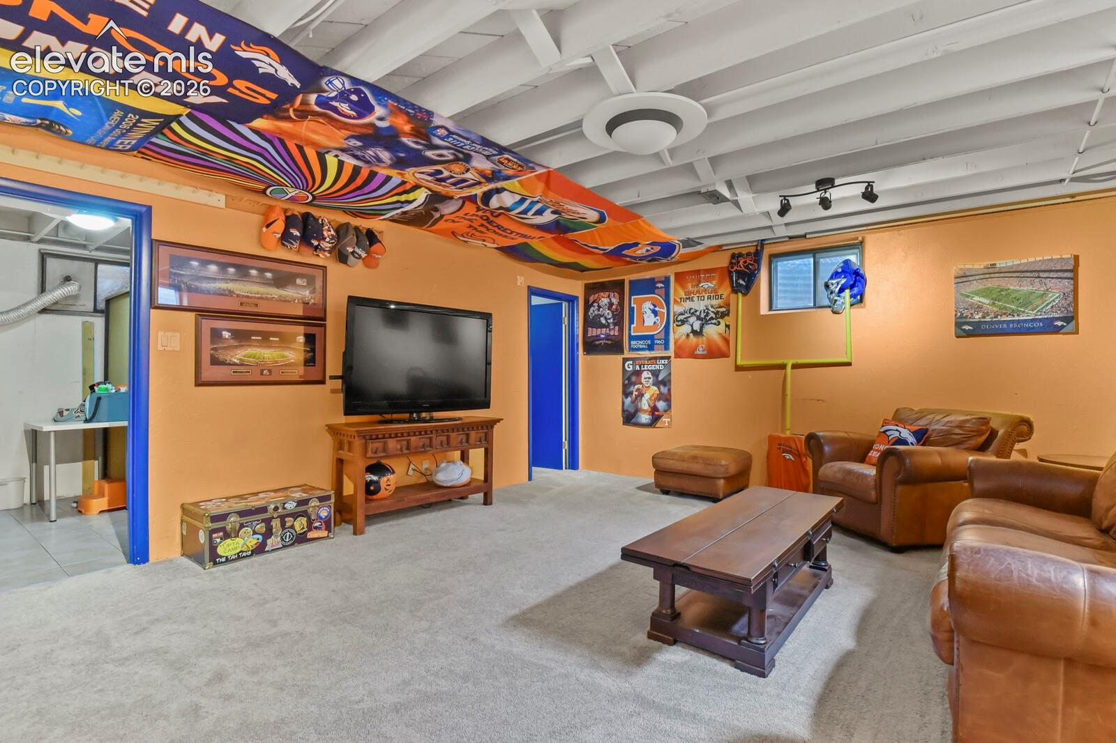 Light-colored carpeting with orange-painted walls and a white exposed beam ceiling