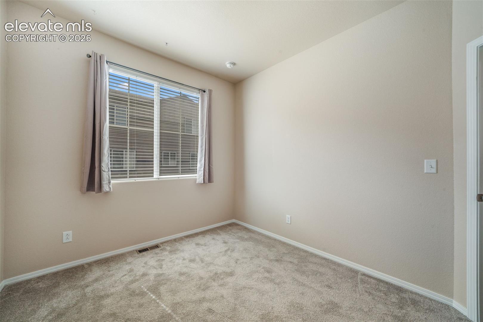 Neutral wall tones, recessed ceiling light, and carpeted flooring