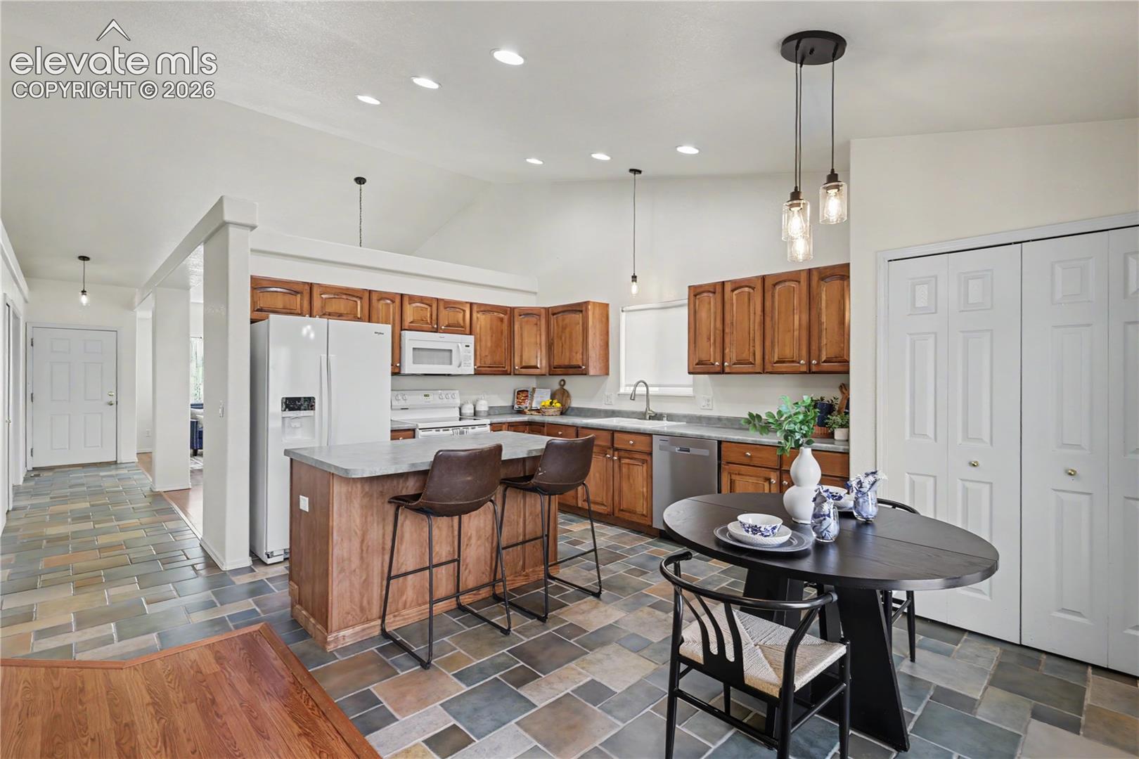 Kitchen featuring wood cabinetry, stone-look countertops, and stainless steel appliances