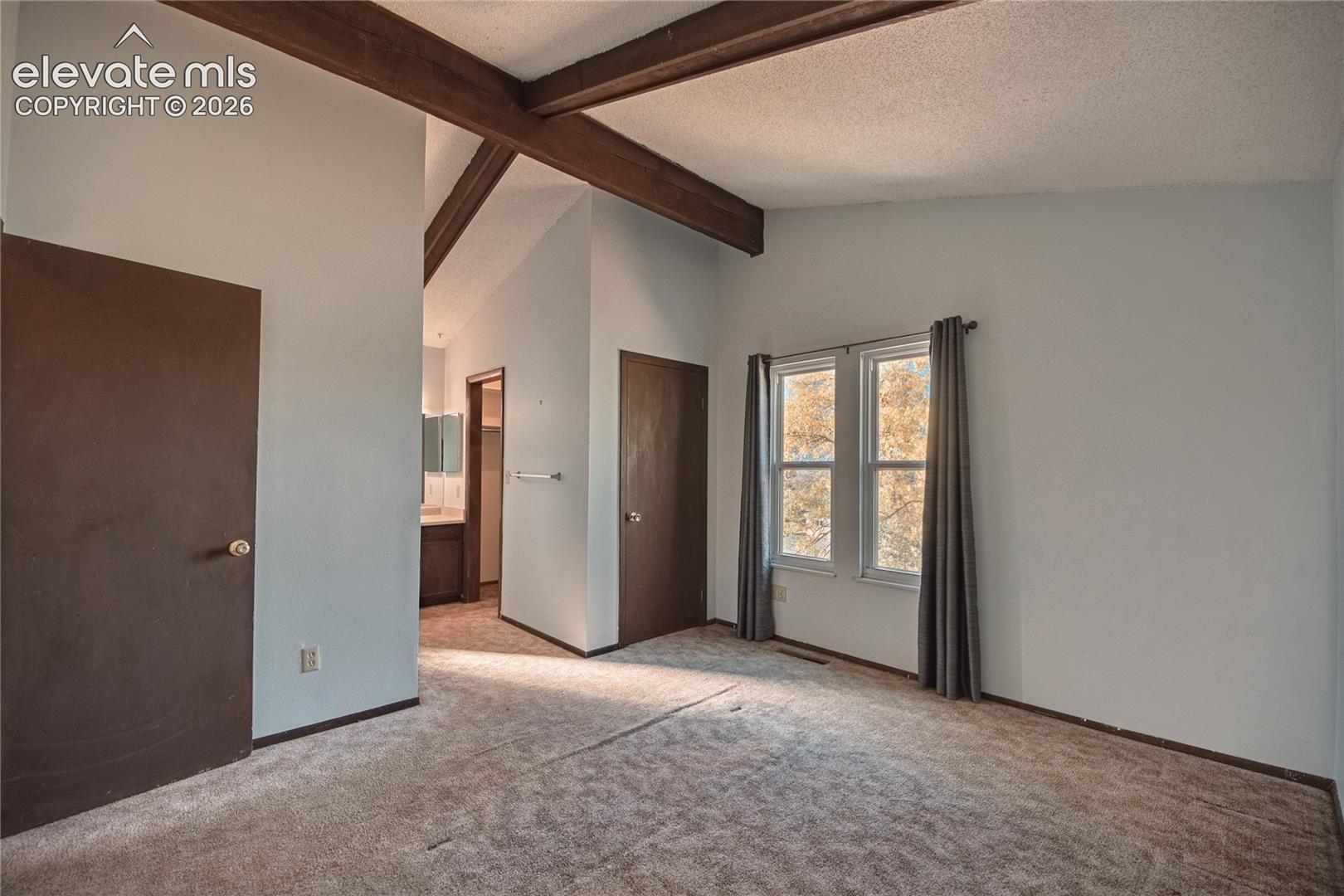 Vaulted ceilings with exposed decorative beams, dual-pane windows, and solid-core interior doors