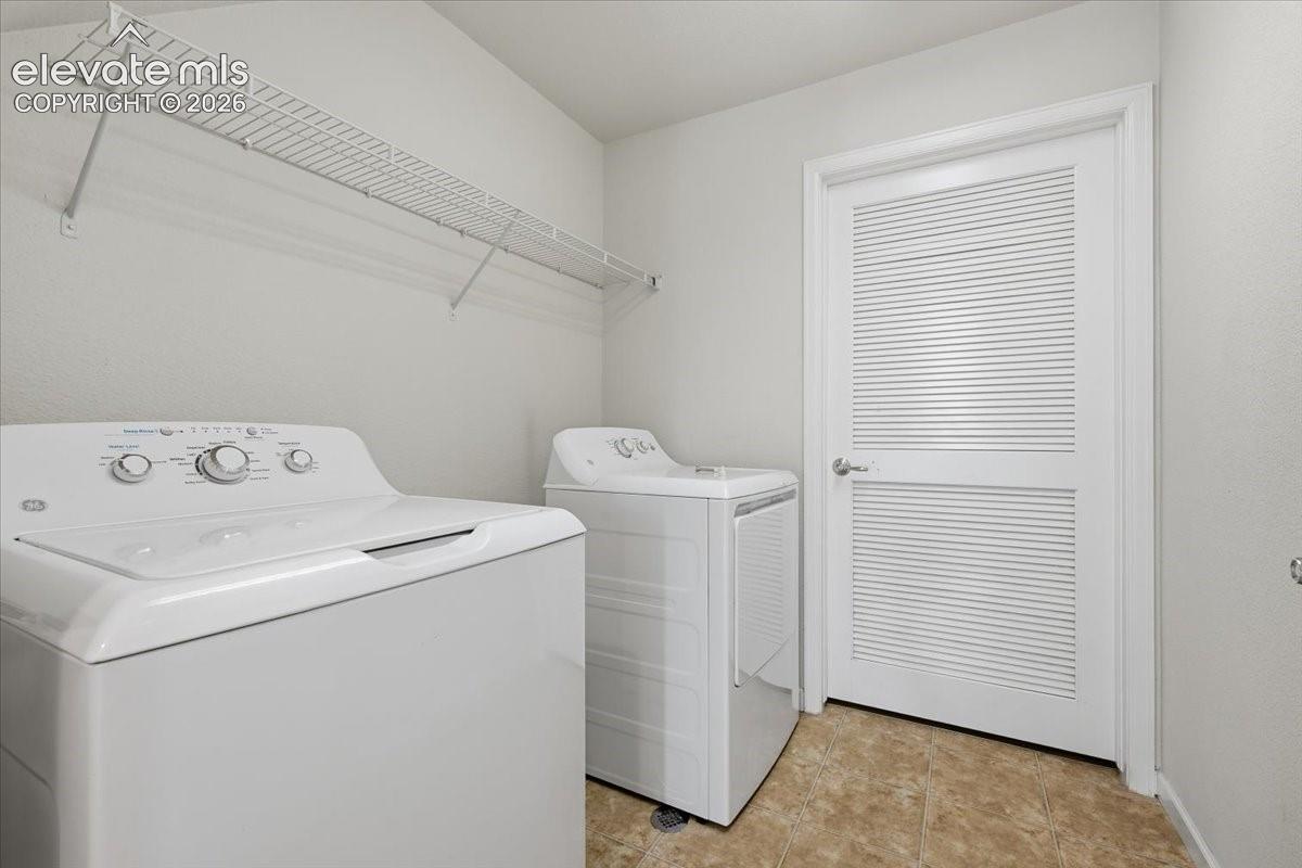 First Level Laundry area featuring a top-load washer, a top-load dryer, and a louvered door to utility and storage