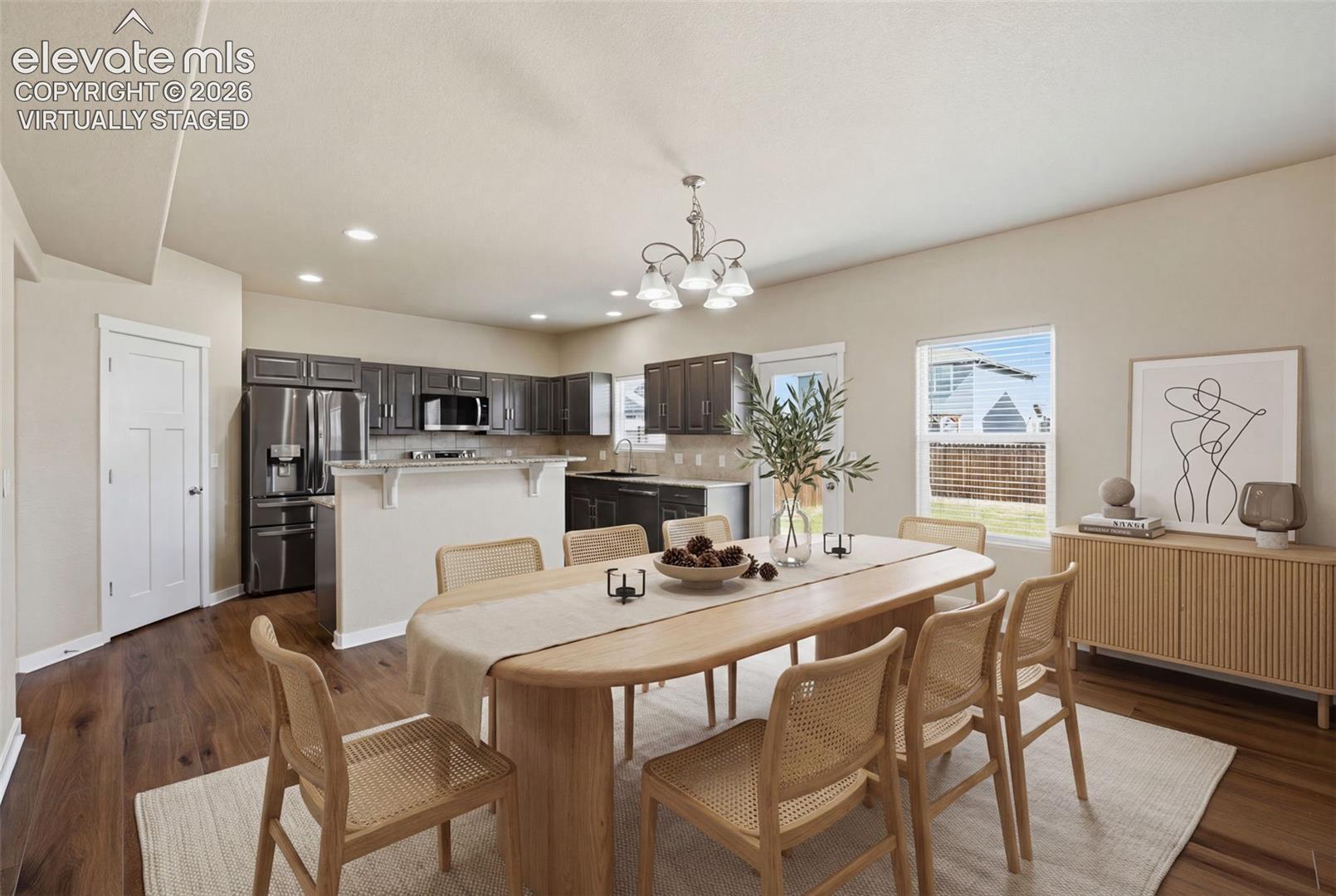Virtually staged to show comfortable seating for a full-size dining table with easy access to the kitchen.