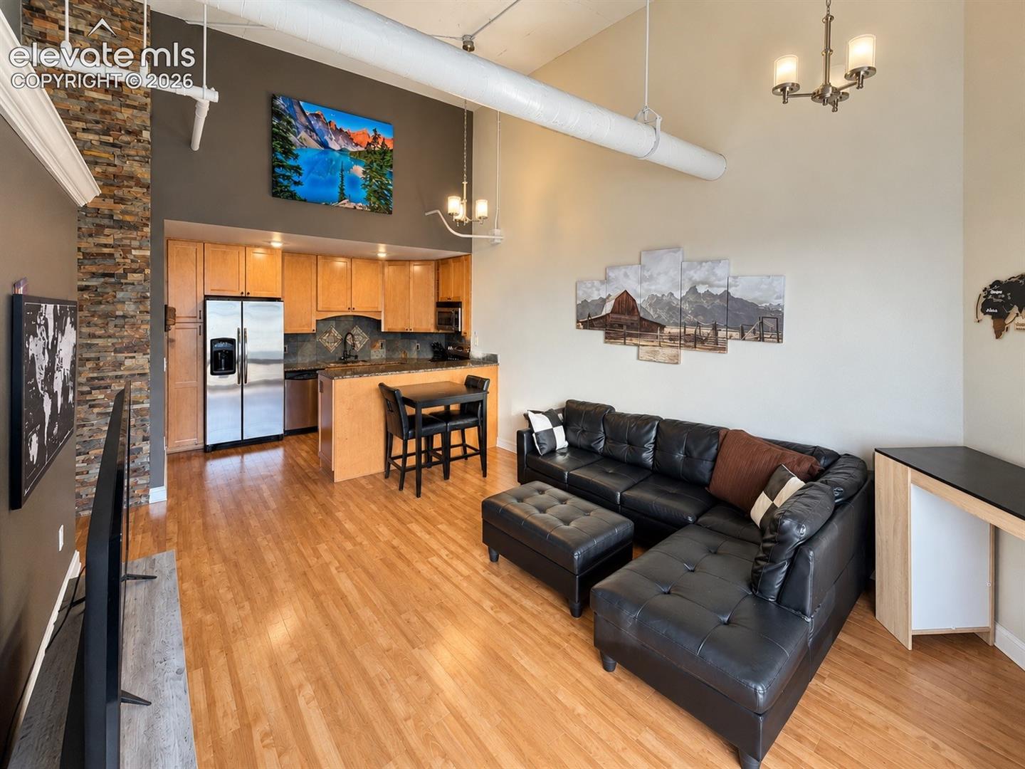 Open-concept living space with high ceilings and wood-finish flooring
