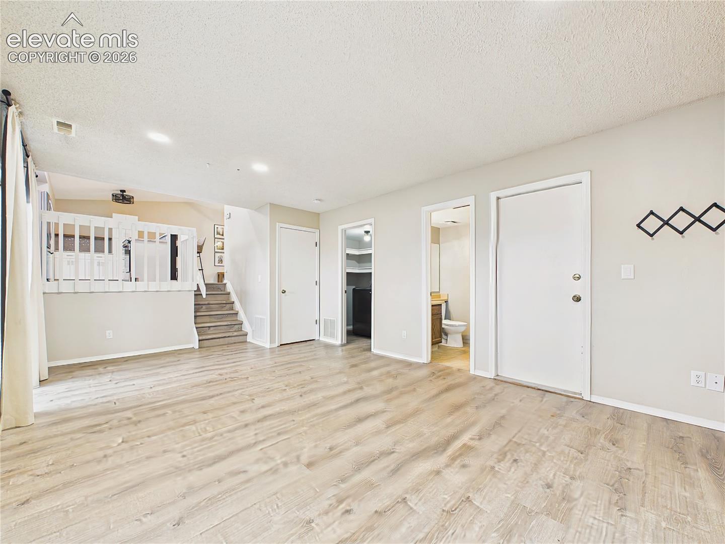 Spacious family room with durable flooring and an open layout, offering flexible space for relaxing, entertaining, or recreation.