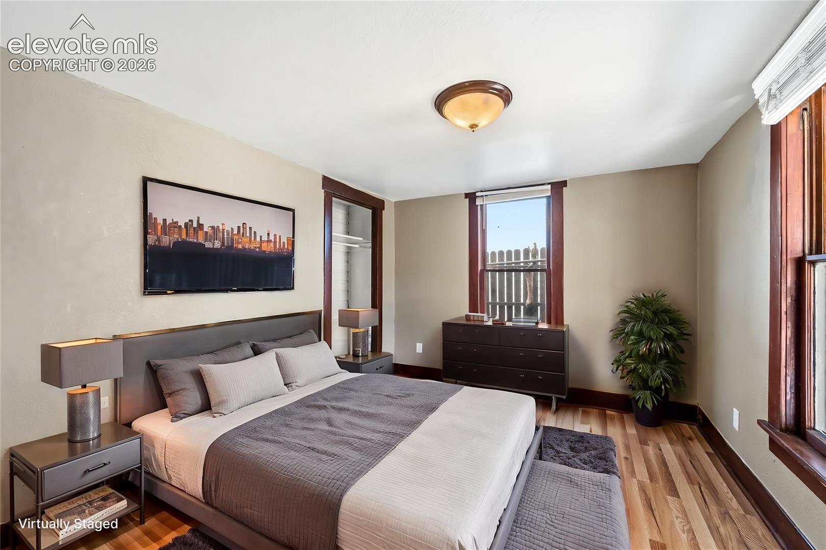 Wood-finish flooring, dark wood-stained window casing and door trim, and ceiling-mounted dome lighting