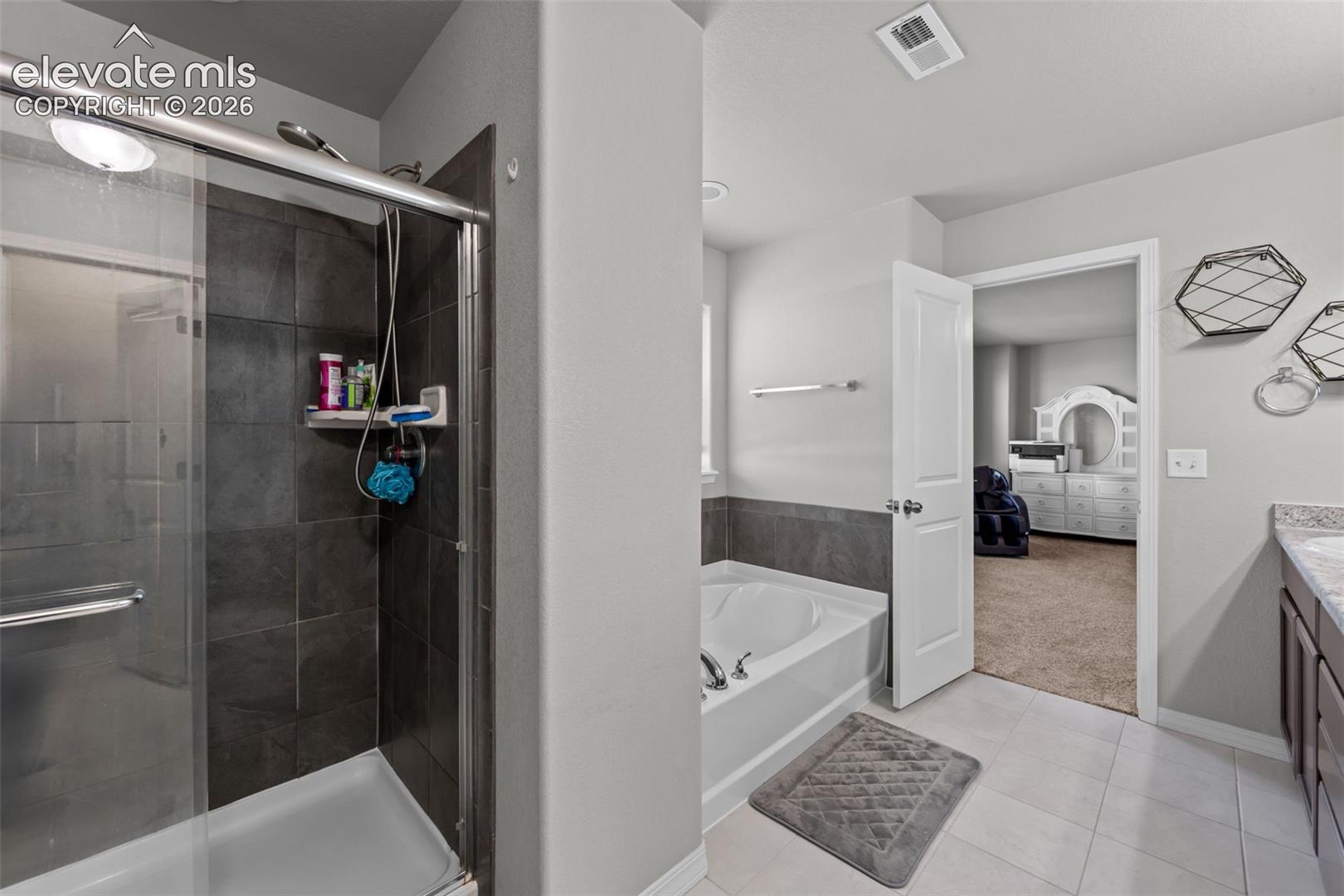 Shower with sliding glass enclosure and dark tile surround