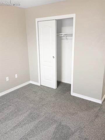 Unfurnished bedroom with a closet and dark carpet