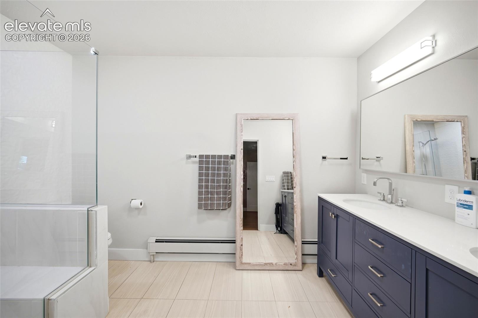 Plenty of counterspace with dual sinks, a quartz countertop and an oversized shower are just some of the features of this elegant bathroom. 