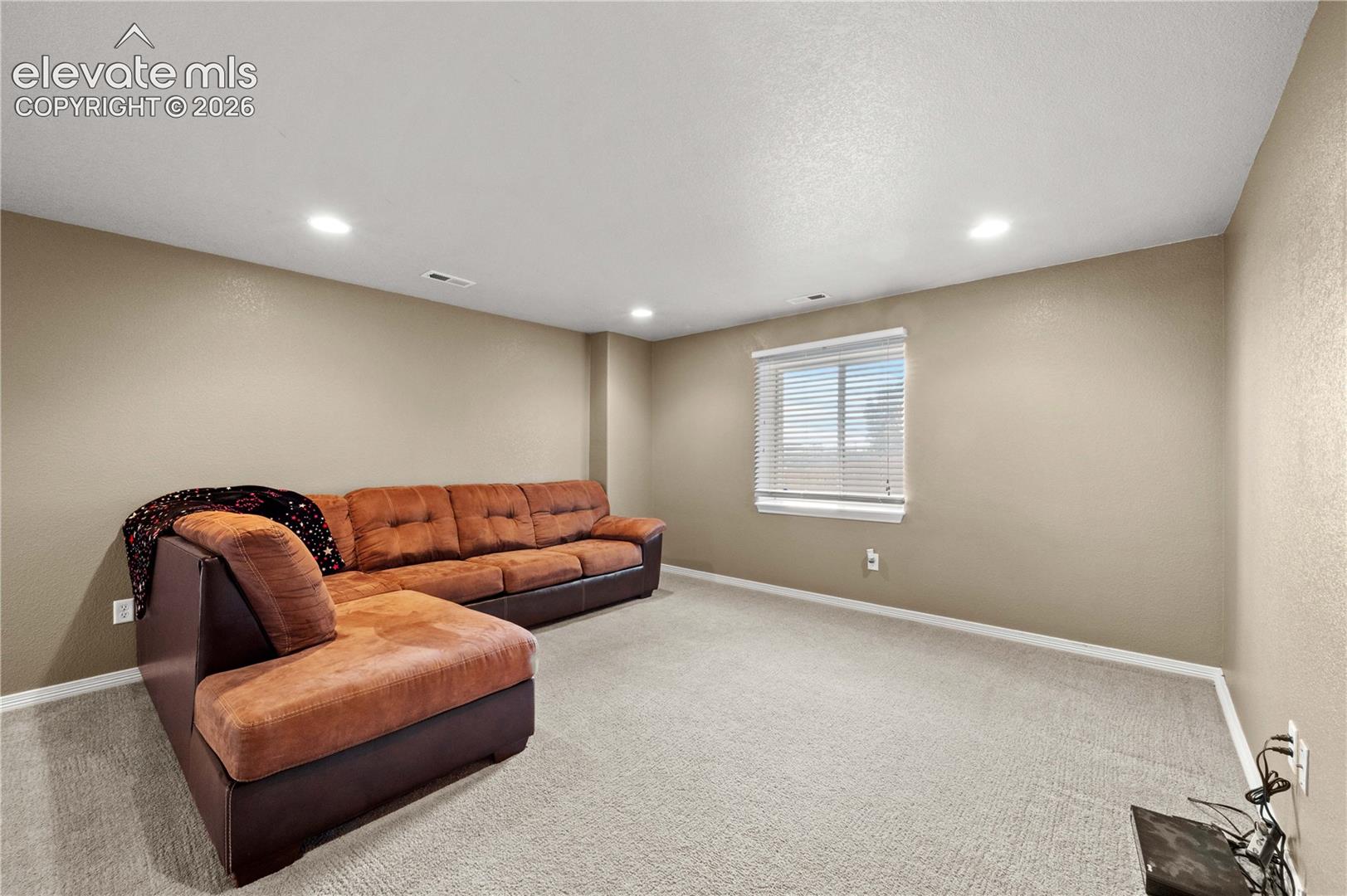 Recessed ceiling lighting, light-toned wall paint, white trim, single window, and neutral carpeting