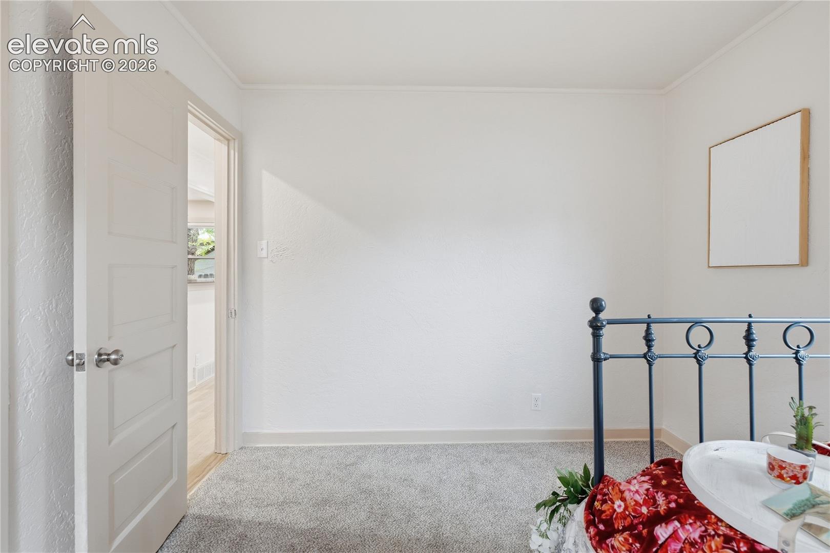 Room interior featuring neutral wall paint, textured wall finish, and wall-to-wall carpeting