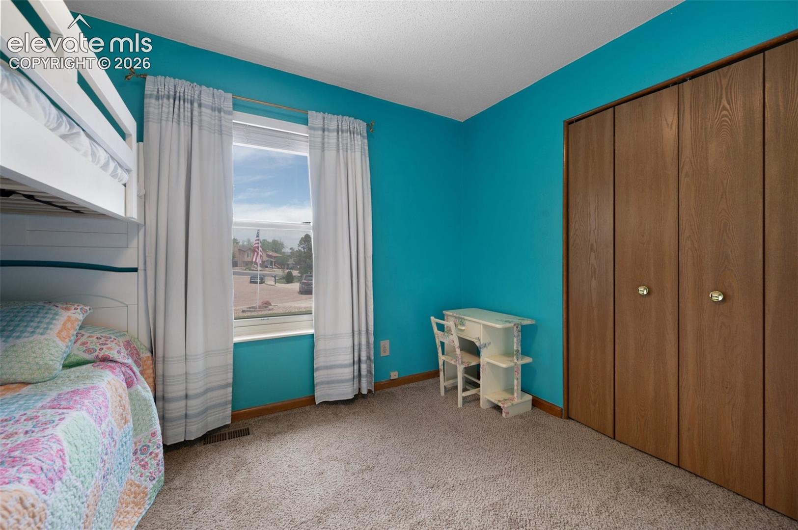 Bedroom with carpet, baseboards, and a closet