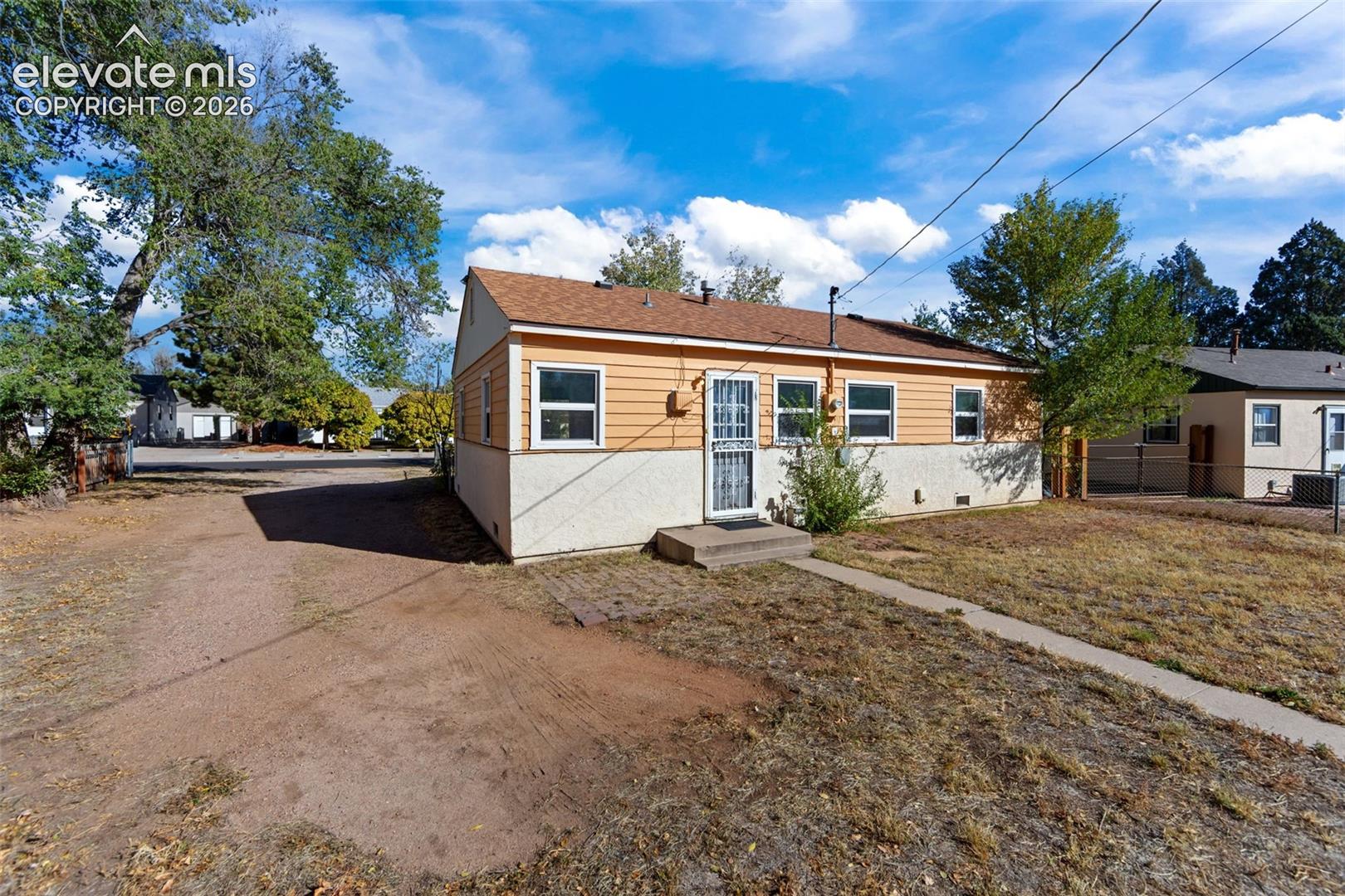 Exterior featuring horizontal siding, stucco base, asphalt shingle roof, and metal storm door