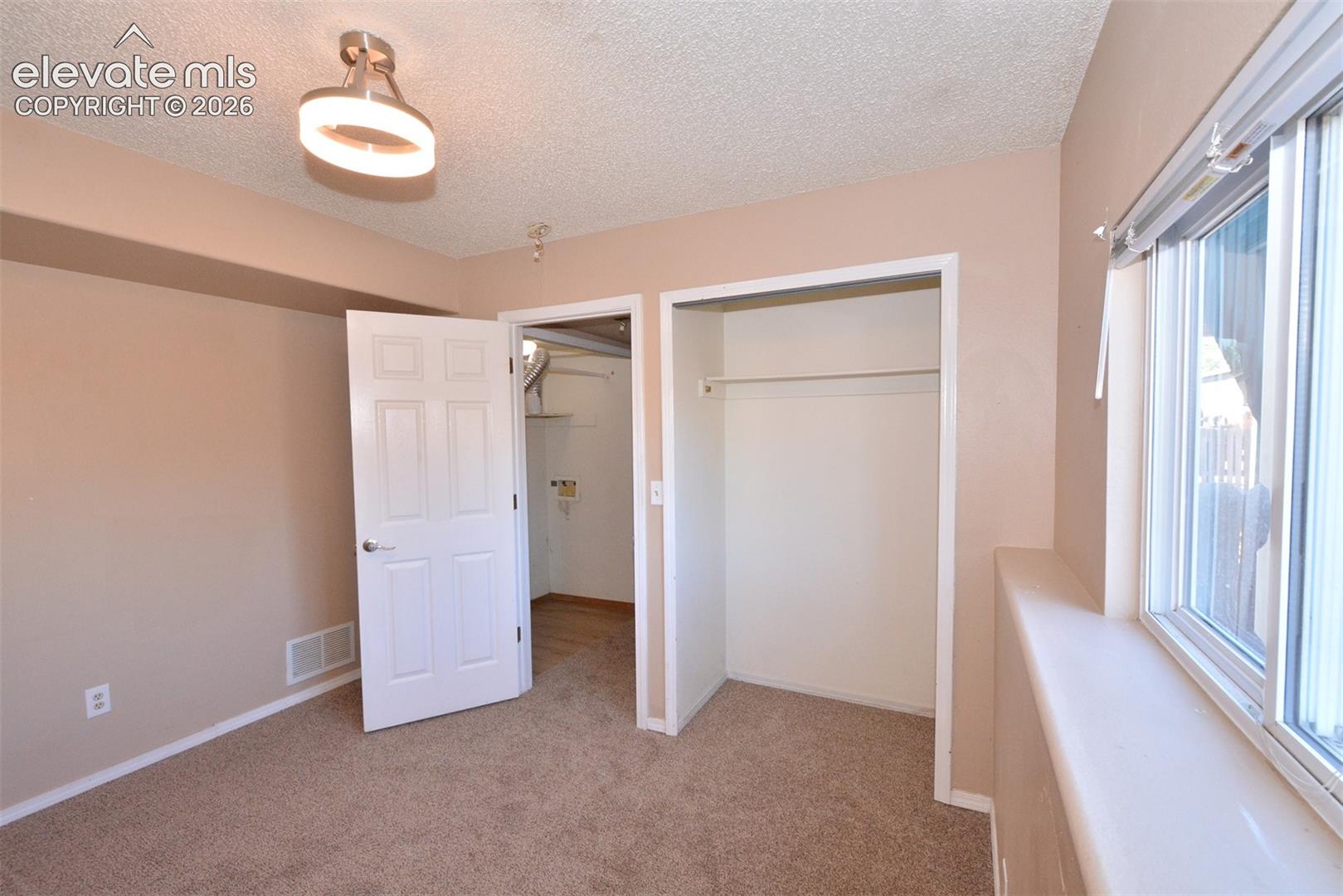 Neutral-toned walls complement the carpeted flooring