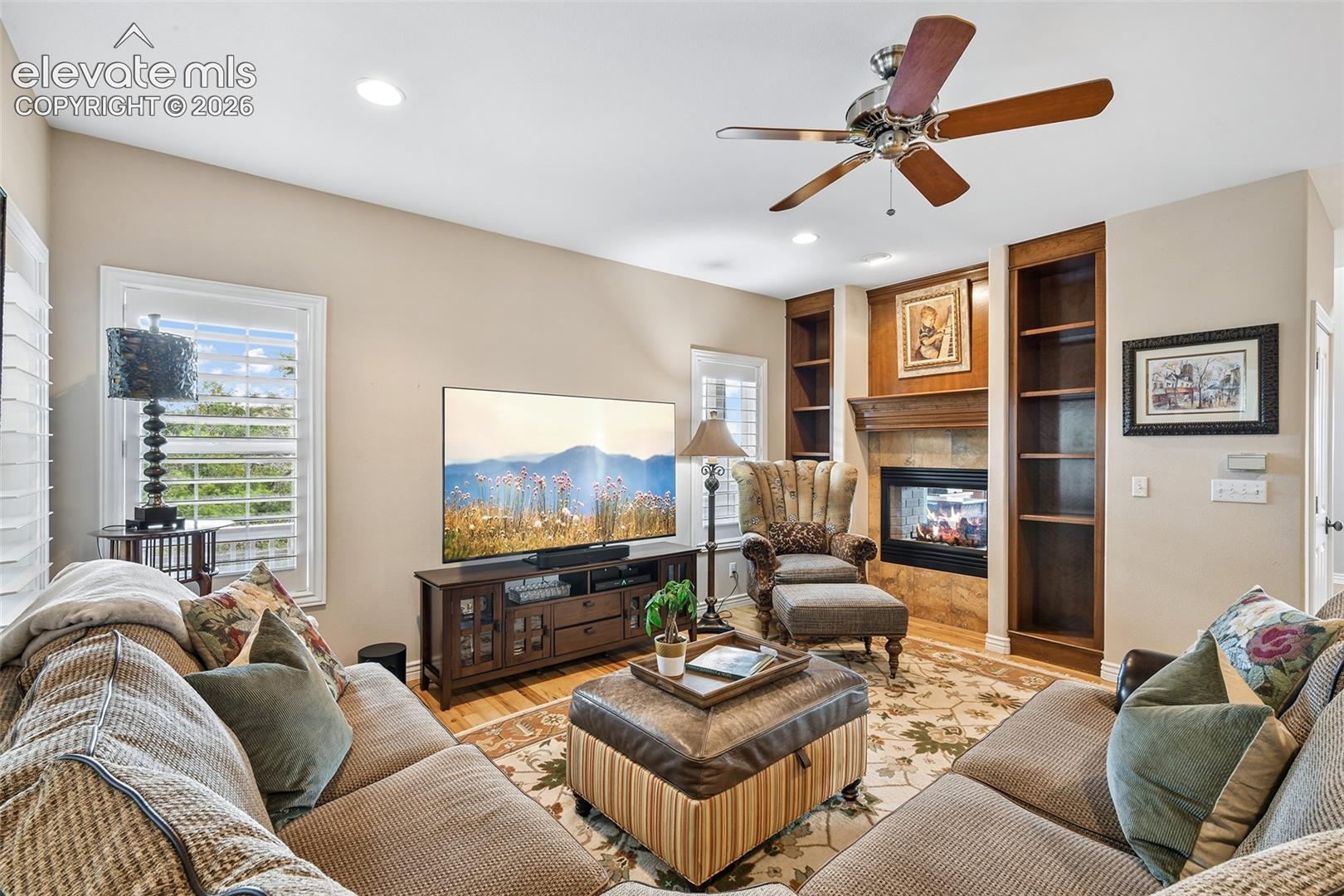 Plantation shutters, and built-ins flanking the two-sided fireplace.