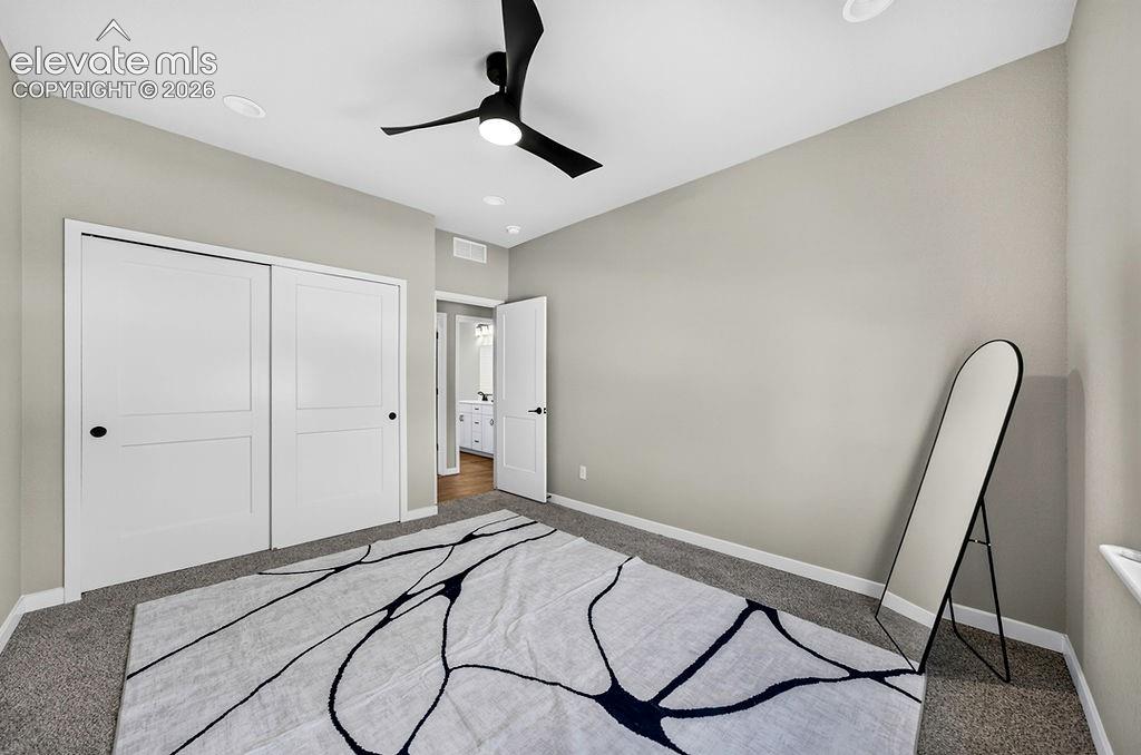 Neutral tone walls with recessed lighting and a black ceiling fan