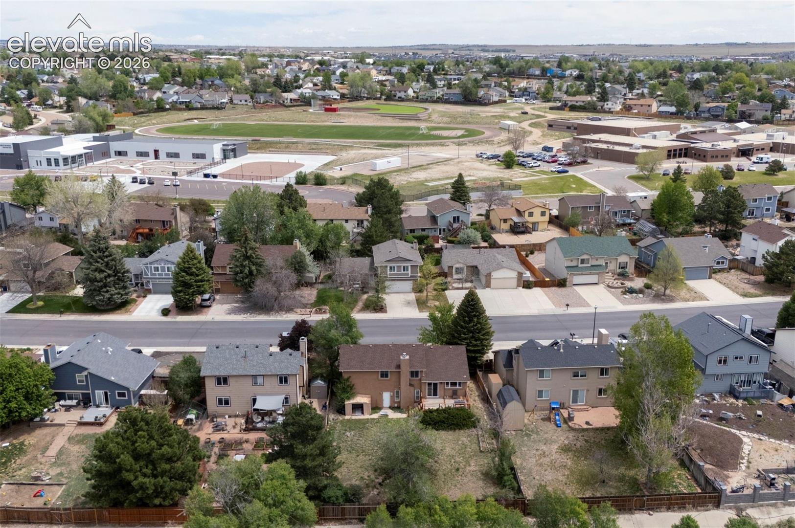 Aerial view showcasing multiple residential properties with varied architectural styles and roofing materials