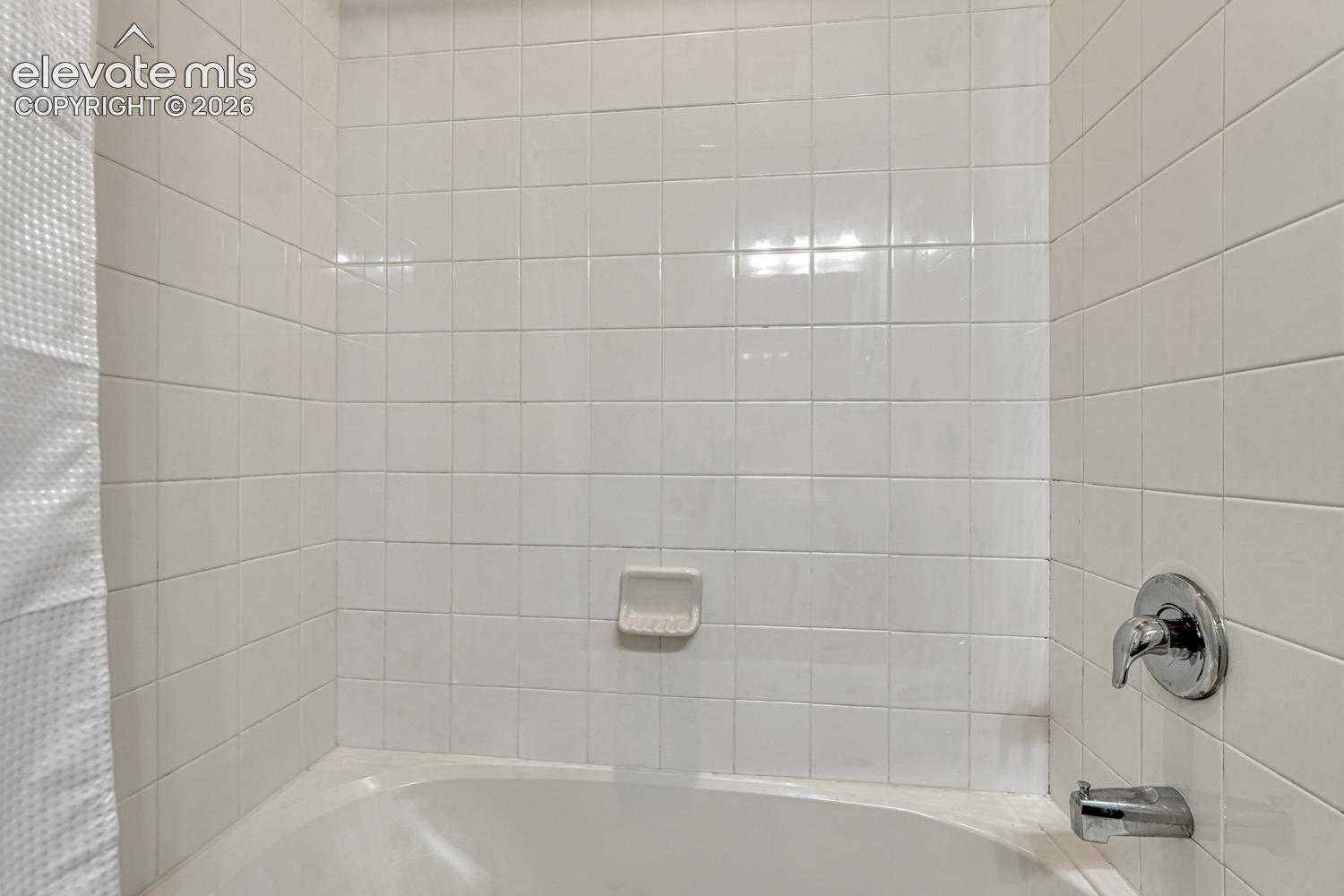Tiled tub/shower in the upper level hall bathroom.