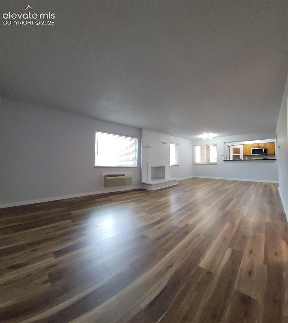 Spacious living area featuring wood-finish flooring throughout