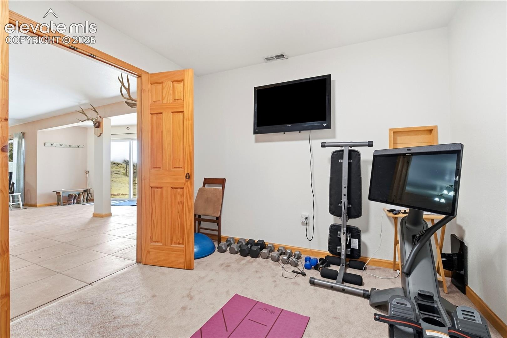 Carpeted flooring, wood-paneled door, and recessed lighting
