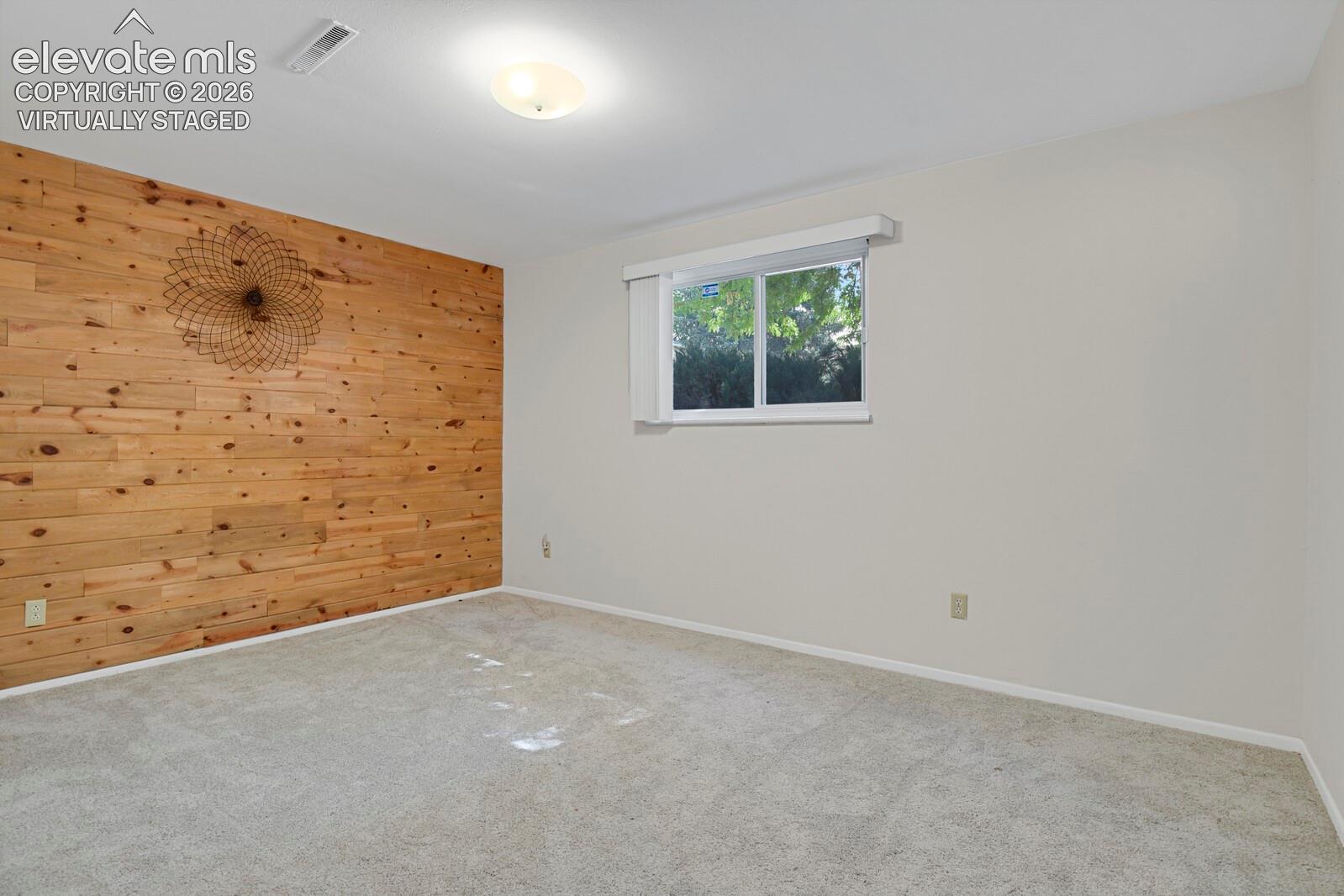 Virtually Staged Bedroom Serene primary bedroom showcasing a wood-accent accent wall with integrated bedside lighting, neutral upholstered bed frame, and soft area rug anchoring the space