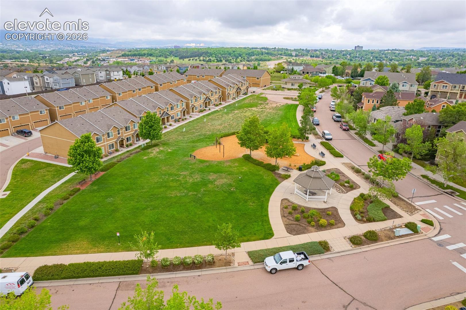 Community green space with a gazebo, paved walking paths, and mature landscaping