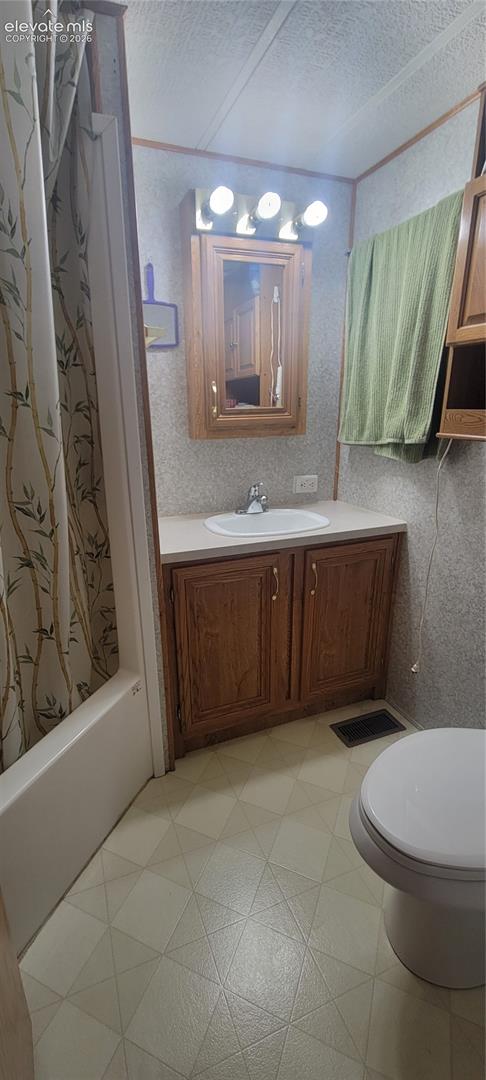 Built-in vanity with wood-finish cabinetry, a white countertop, and an integrated sink