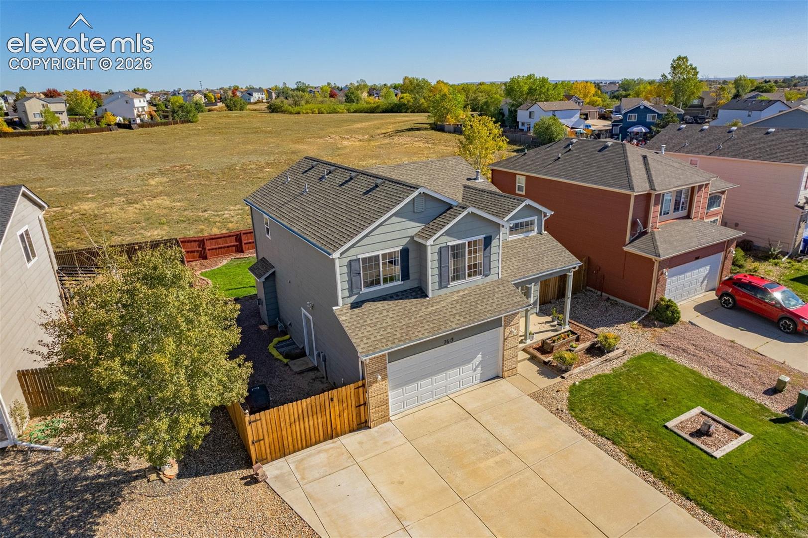 Two-story residence featuring composite shingle roofing, dual-tone siding, an attached two-car garage, and an expansive concrete driveway