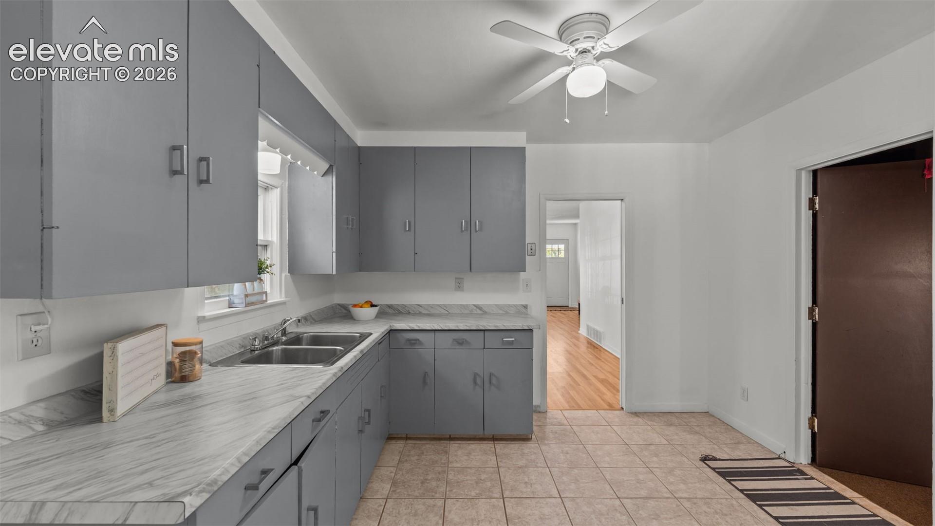 Chef's kitchen featuring gray cabinetry with ample storage, marble-finish countertops, stainless steel appliances including a gas cooktop, and an island workspace