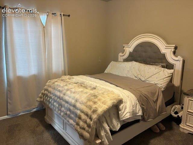 Neutral-toned interior space featuring neutral wall paint, wall-to-wall carpeting, and a window with a metal rod fixture