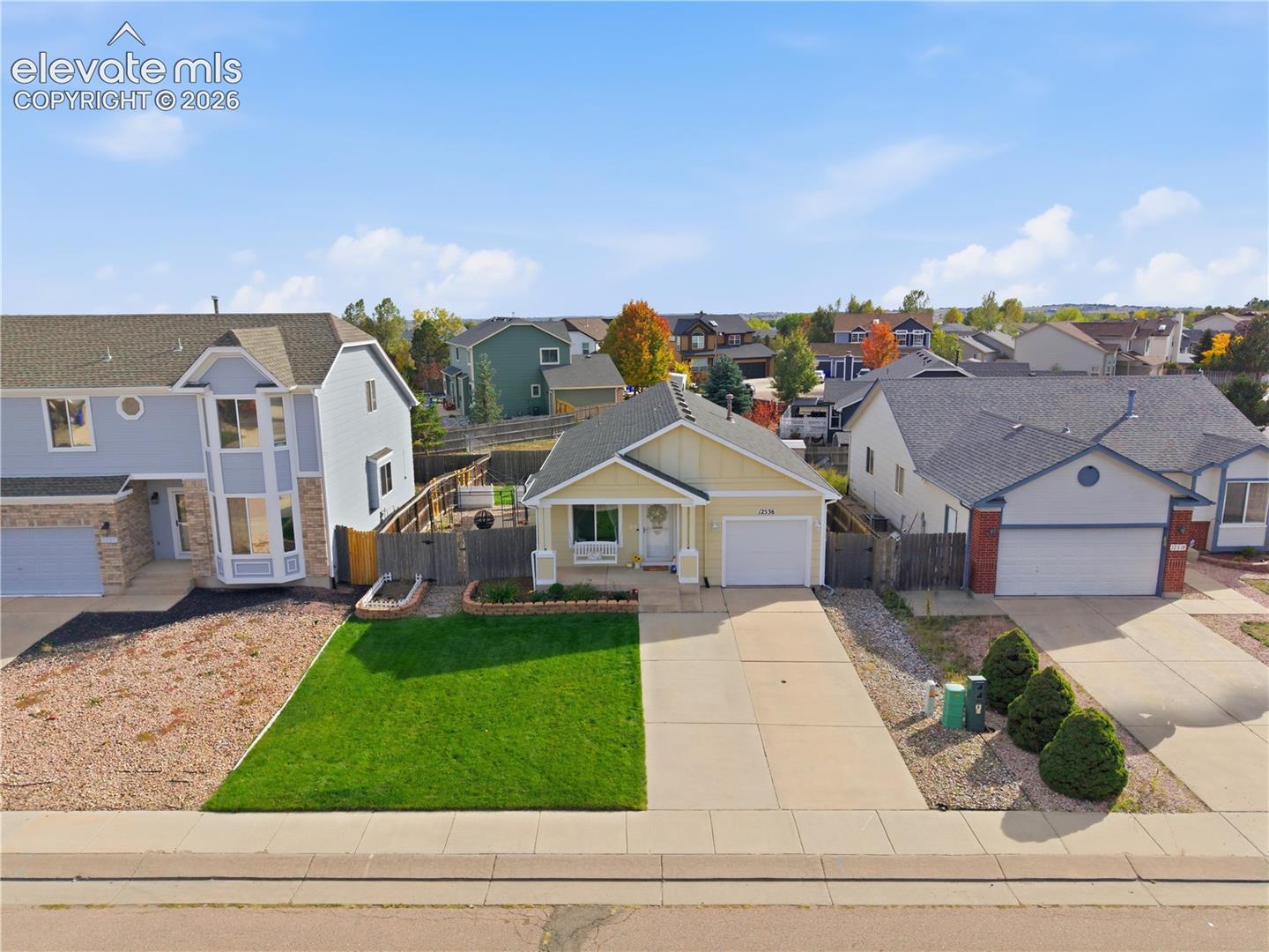 Single-story residence featuring an attached garage, concrete driveway, and a front lawn