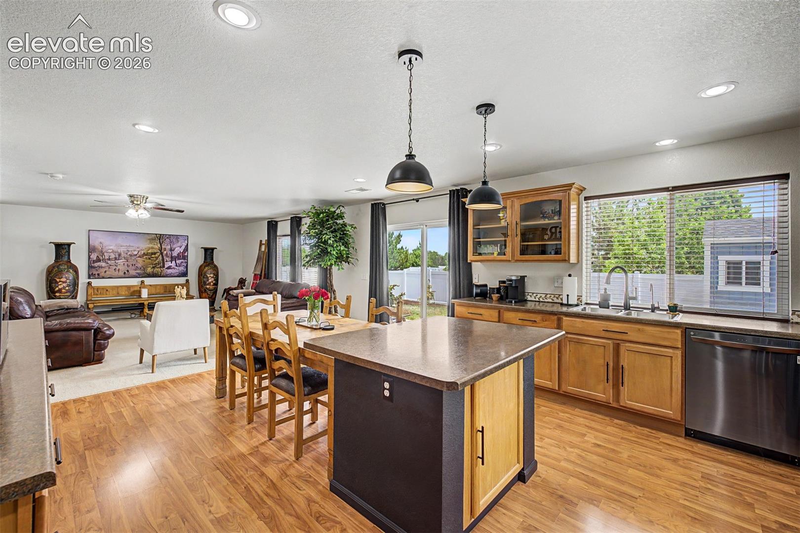 The kitchen's expansive island doubles as a gathering spot, with abundant counter space, built-in outlets, and pendant lighting that sets the mood for everything from morning coffee to evening entertaining.