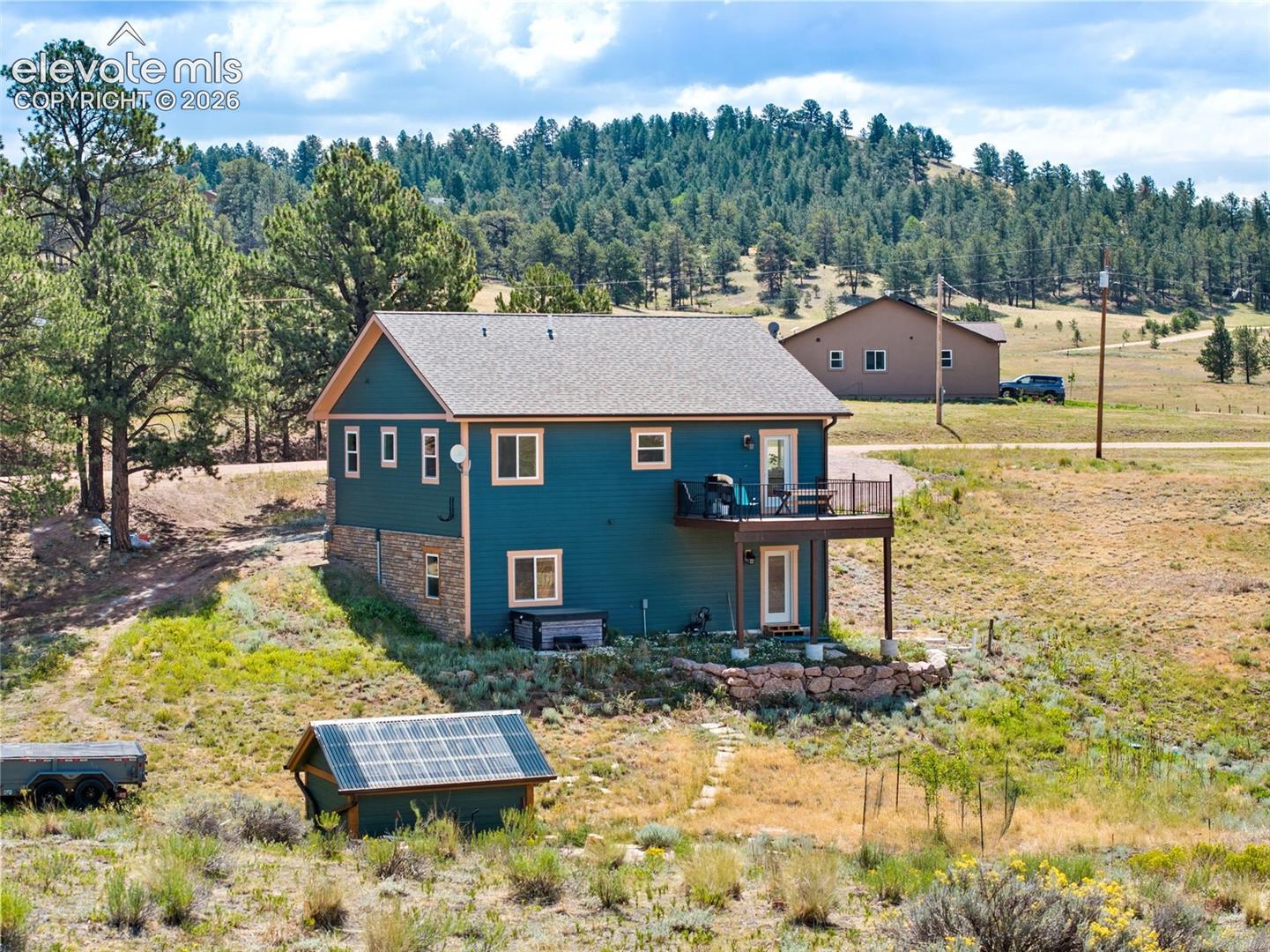 Rear exterior featuring a spacious deck and greenhouse.