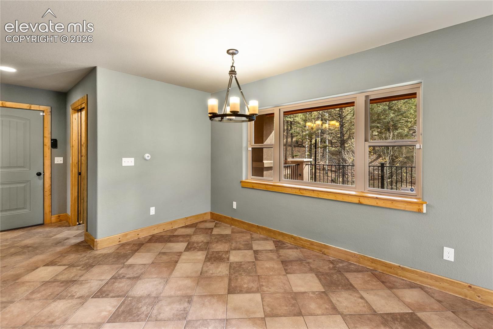 Tile flooring, multi-pane window with natural wood trim, and custom iron chandelier
