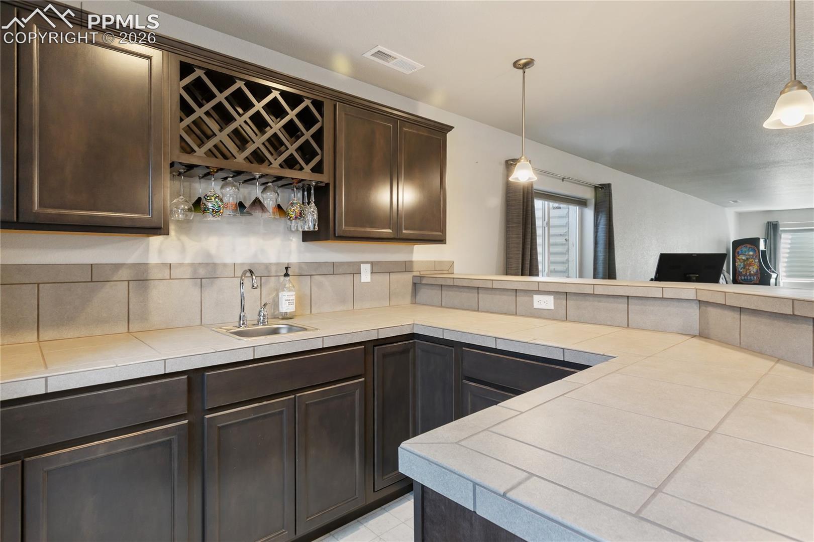 Bar with tile counters and built-in wine storage