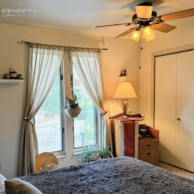 Room featuring neutral-toned walls, a ceiling fan with integrated lighting, and a large 
window with sheer drapes
