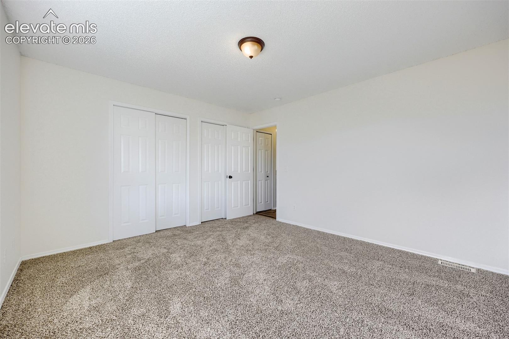 Wall-to-wall carpeting and white walls