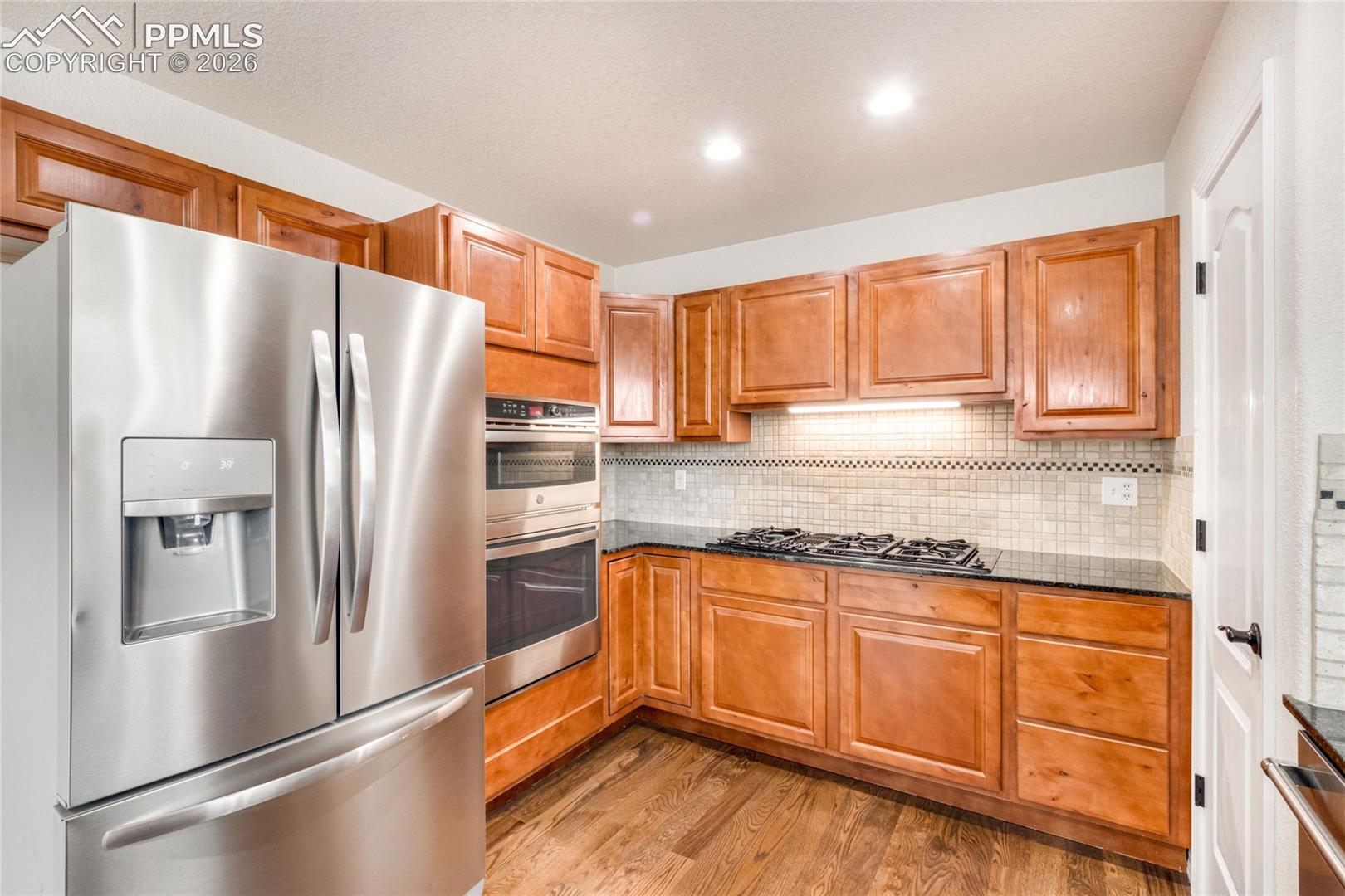 Stainless Steel appliances, rich wood cabinetry, GenAir cooktop and corner pantry.