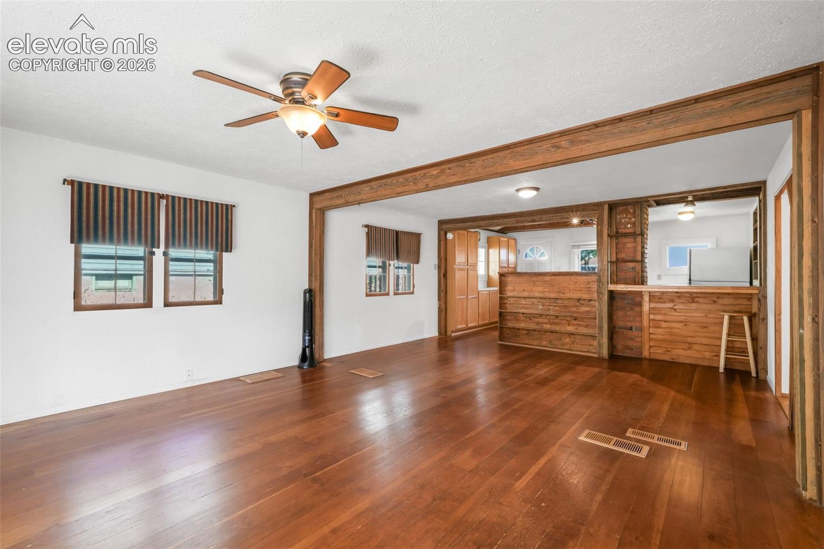 Wood-finish flooring throughout, with a wood-accented doorway and a built-in wood bar