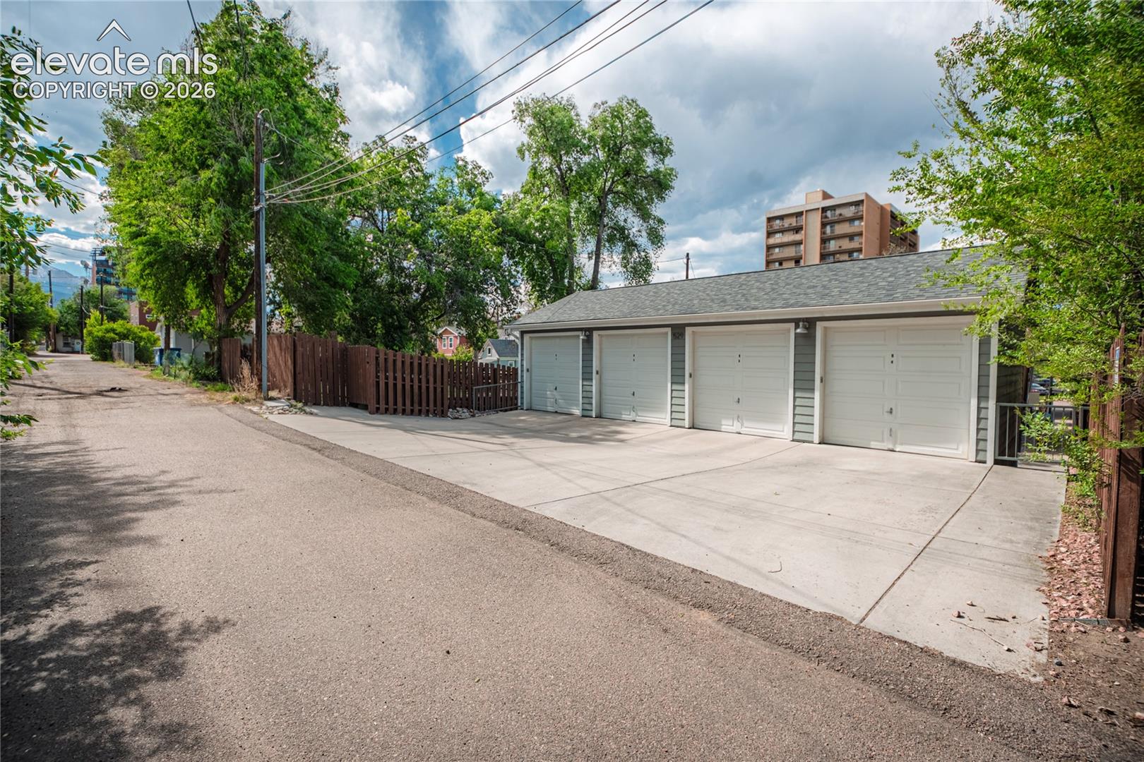 Four individual garage bays with white panel doors