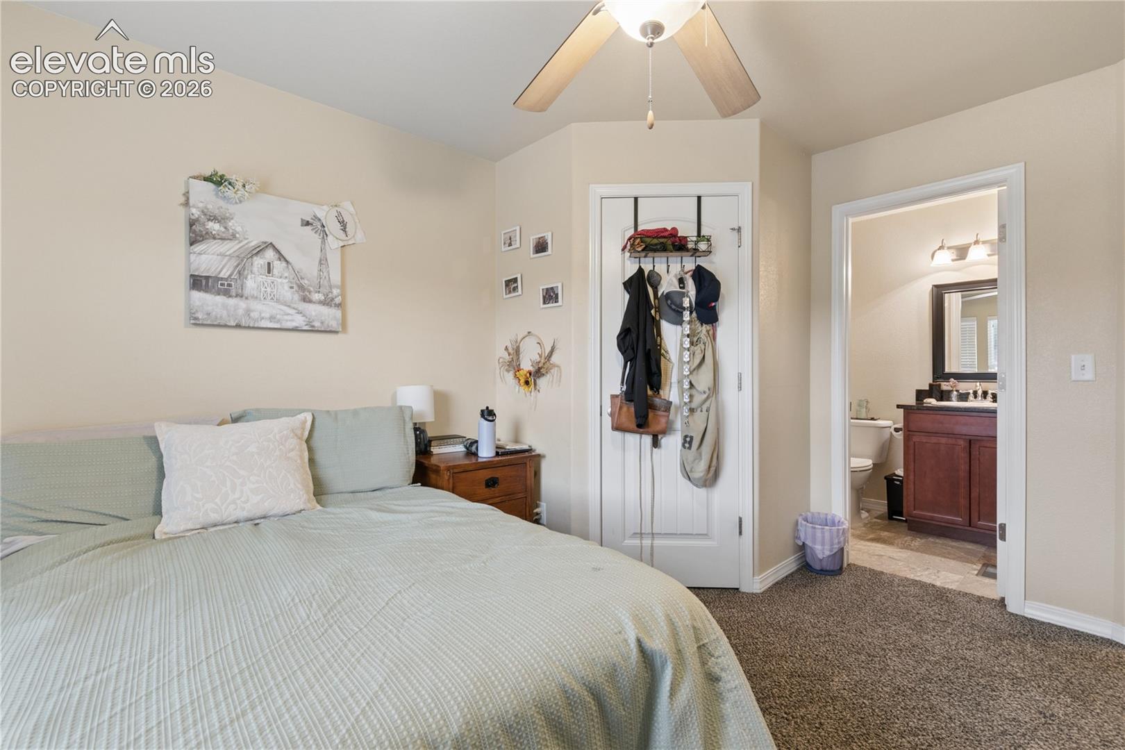 Carpeted room with neutral wall tones and a ceiling fan